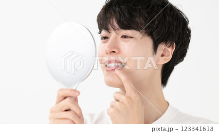 手鏡で歯を確認する男性 123341618
