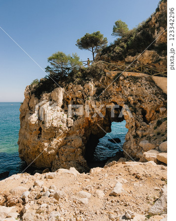 Stunning and Scenic Coastal Arch Landscape featuring Crystal Clear Blue Waters. Experience breathtaking coastal view boasting natural rock arch backdrop of serene blue sea. vertical, film look Stunning and Scenic Coastal Arch Landscape featuring Crystal Clear Blue Waters. Experience breathtaking coastal view boasting natural rock arch backdrop of serene blue sea. vertical, film look 123342296