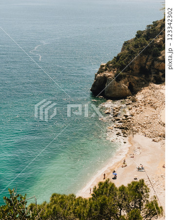 Enjoy serene coastal view featuring crystal clear water along with beautiful sandy beach. stunningly coastal scenery showcases turquoise waters alongside picturesque sandy shores. vertical, film look 123342302