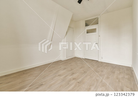 A clean and minimalist room featuring white walls and a wooden floor, showcasing simplicity and tranquility in interior design. A clean and minimalist room featuring white walls and a wooden floor, showcasing simplicity and tranquility in interior design. 123342379