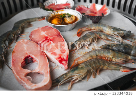 Seafood is grilled at buffet in Asian restaurant in Asia in Vietnam. Fish and shrimp are fried on stove 123344019