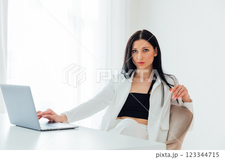 Brunette Woman In White Business Suit With Laptop Online In Office At Training 123344715