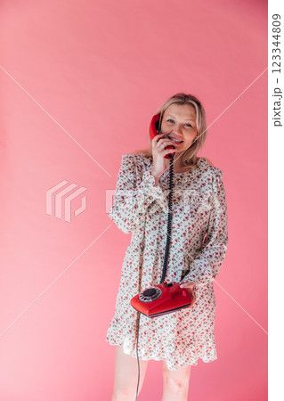 woman holding receiver from retro phone for conversation 123344809