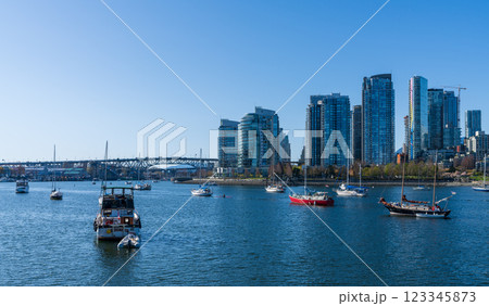 Vancouver, BC, Canada - April 16 2021 : Vancouver marina, False Creek, modern buildings skyline in the background. Granville Bridge. Vancouver, BC, Canada - April 16 2021 : Vancouver marina, False Creek, modern buildings skyline in the background. Granville Bridge. 123345873