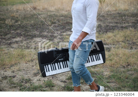 Italian Boy Walks Playing Musical Keyboard On Shoulder In Nature Calabria Italian Boy Walks Playing Musical Keyboard On Shoulder In Nature Calabria 123346004