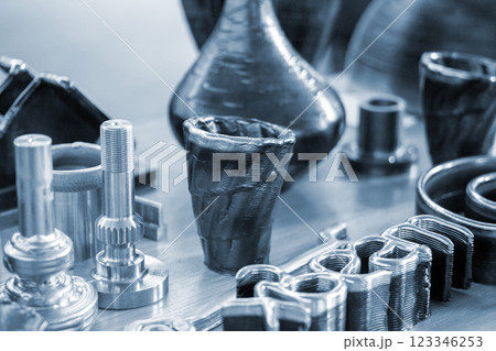 Objects printed with a 3D printer from a filament of molten metal on a table. Objects printed with a 3D printer from a filament of molten metal on a table. 123346253