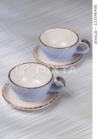 Ceramic clay cups and saucers on a gray background. Ceramic clay cups and saucers on a gray background. 123346498