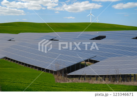 Rows of solar panels, wind turbine and green nature Rows of solar panels, wind turbine and green nature 123346671