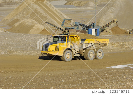 Yellow dump truck working in gravel pit Yellow dump truck working in gravel pit 123346711