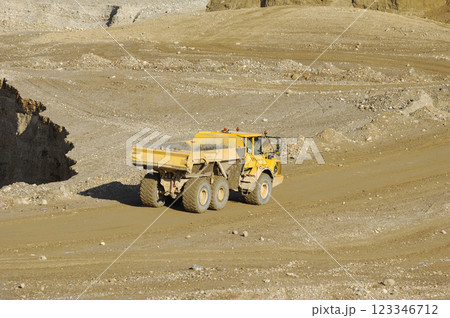 Yellow dump truck working in gravel pit Yellow dump truck working in gravel pit 123346712