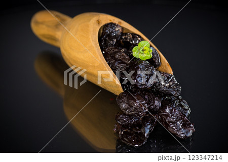 Wooden spoon with prunes and herbs on a black background 123347214