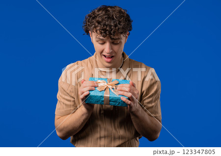 Happy Hipster Man With Gift Box, Blue Background. Guy Smiling, What's Inside. 123347805