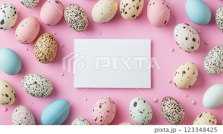 Colorful easter eggs arranged around a blank paper on a soft pastel pink background 123348425