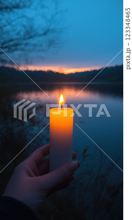 Lighting the Easter candle by the lakeside at dusk for a moment of peace and reflection 123348465
