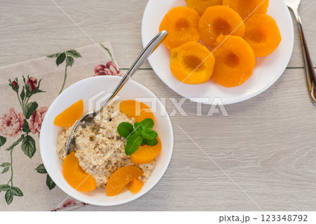 Nutritious milk porridge with pieces of sweet peaches Nutritious milk porridge with pieces of sweet peaches 123348792