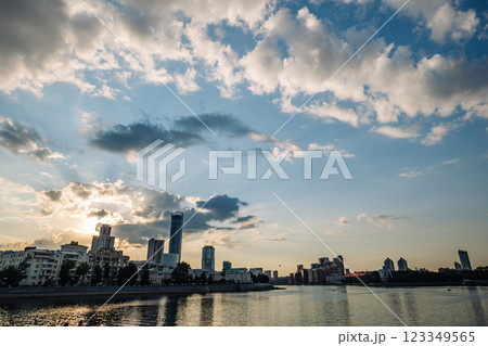 Modern buildings along the iset river in yekaterinburg, russia, create a stunning cityscape under a dramatic sunset sky with beautiful clouds 123349565