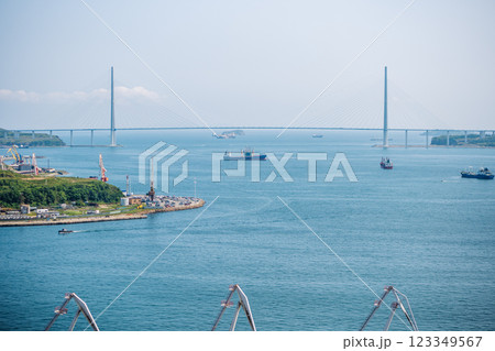 Cargo ships navigating eastern bosphorus strait under russky bridge, connecting vladivostok city with russky island Cargo ships navigating eastern bosphorus strait under russky bridge, connecting vladivostok city with russky island 123349567