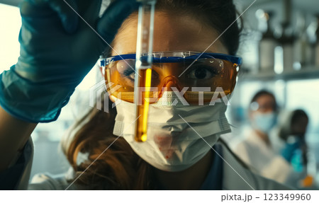 focused female scientist in glasses and purple gloves holds up test tube with biotech sample liquid, biotechnology experiment in laboratory environment 123349960