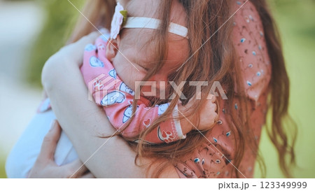 Mother gently hugging infant daughter, sharing intimate maternal bond and emotional warmth 123349999