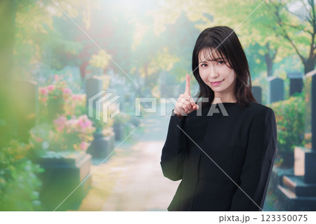 喪服を着てお墓参りをする女性 喪服を着てお墓参りをする女性 123350075