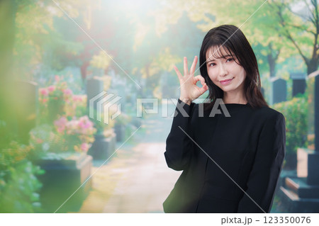 喪服を着てお墓参りをする女性 喪服を着てお墓参りをする女性 123350076