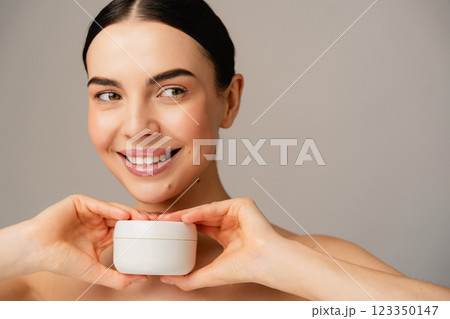 Smiling Female with Skin Cream Jar Promoting Beauty and Skincare Routine 123350147
