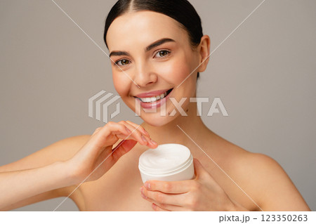 Smiling Woman Applying Cream for Healthy and Radiant Skin Care Smiling Woman Applying Cream for Healthy and Radiant Skin Care 123350263