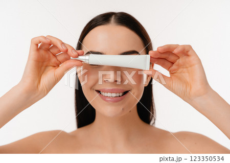 Smiling Woman Holding Cosmetic Product in Minimalist Style Smiling Woman Holding Cosmetic Product in Minimalist Style 123350534
