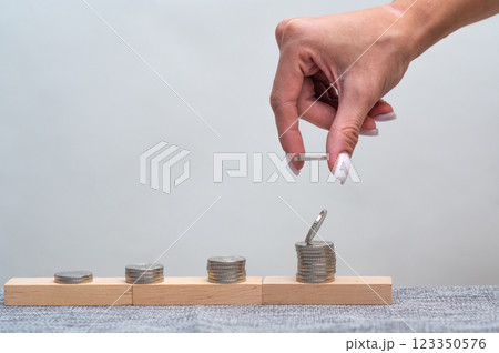 hand puts money and coins in piles, the amount grows. concept 123350576