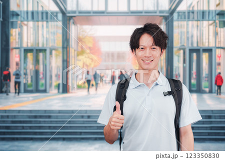 大学のキャンパス内を歩く男子学生 123350830