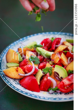 Fresh spring salad witn avocado, tomato, peach, red onion and herbs 123350966