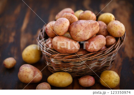 Raw fresh potatoes in the basket on wooden background 123350974