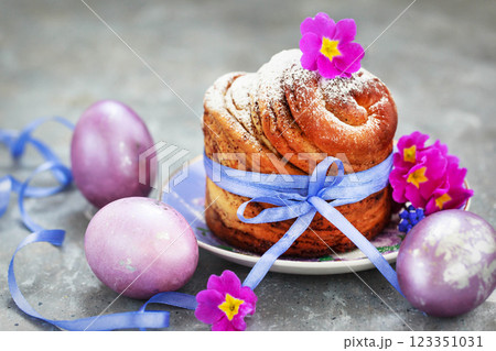 Sweet Easter bread, panettone or cruffin and colorful painted eggs, Holiday spring concept Sweet Easter bread, panettone or cruffin and colorful painted eggs, Holiday spring concept 123351031