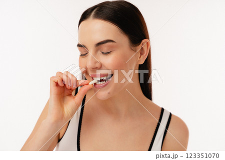 Young Woman Enjoying A Healthy Snack in a Bright Studio Setting 123351070