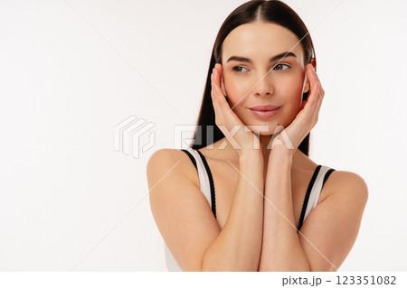 Beautiful Woman Gently Touching Face with Graceful Expression and Relaxed Posture Beautiful Woman Gently Touching Face with Graceful Expression and Relaxed Posture 123351082