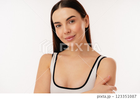 Confident Woman Smiling in Minimalist Studio Against a White Background 123351087