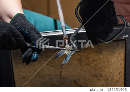 Molten glass and tools, works of a  glass blowing workshop 123351408