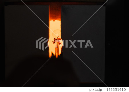 Glowing open furnace with molten glass inside. Glass blowing workshop 123351410