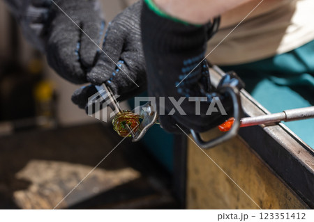 Molten glass sculpting, works of a glass blowing workshop Molten glass sculpting, works of a glass blowing workshop 123351412