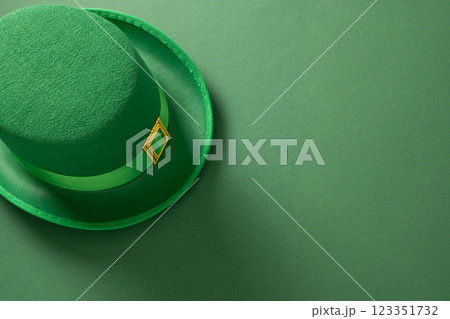 St Patricks day and March 17 concept with green Leprechaun Hat and green coins on green background. View from above. Copy space. 123351732
