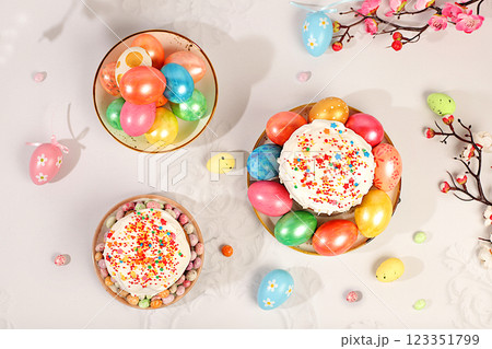 Happy Easter concept. Abstract Easter composition with traditional Russian kulich with meringue and decorated eggs on elegant kitchen table with spring sakura flowers. Screen banner with space for 123351799