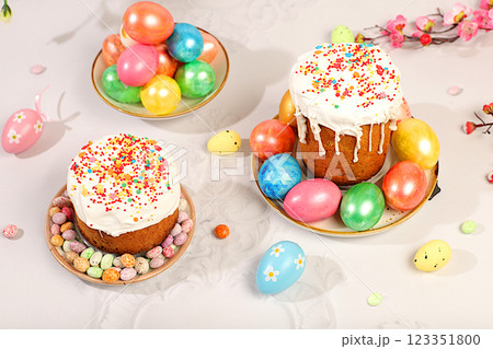 Abstract Easter composition with traditional Russian kulich with meringue and decorated eggs on elegant kitchen table with spring sakura flowers. Happy Easter concept. Screen banner 123351800