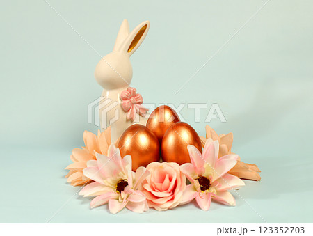 Abstract easter composition with painted golden eggs, bunny and spring flowers. Holiday design template and banner for screen, minimal easter concept, selective focus.. 123352703