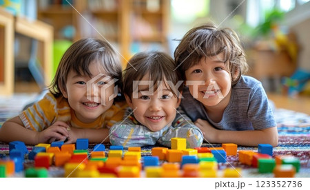 Three boys smile as they play with construction blocks. 123352736