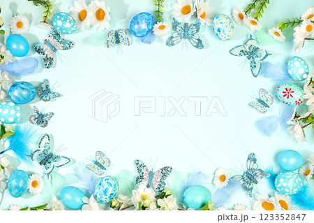 Happy Easter concept. Abstract spring Easter composition with blue painted eggs, feathers, butterflies, flowering branches and flowers. Screen banner with space for greeting text, 123352847