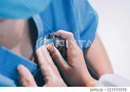 Homecare nursing service and elderly people cardiology healthcare. Close up of young hispanic female doctor nurse check mature caucasian man patient heartbeat using stethoscope during visit 123353056