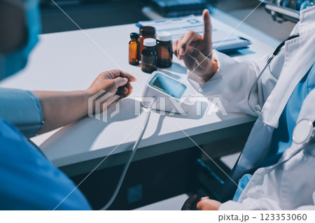 Doctor using sphygmomanometer with stethoscope checking blood pressure to a patient in the hospital. Doctor using sphygmomanometer with stethoscope checking blood pressure to a patient in the hospital. 123353060