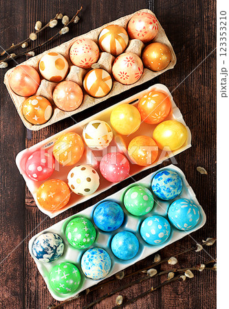 Composition with decorated Easter eggs in a box and willow branches. Happy Easter concept, banner or advertisement for screen or store, template for design, spring card, selective focus Composition with decorated Easter eggs in a box and willow branches. Happy Easter concept, banner or advertisement for screen or store, template for design, spring card, selective focus 123353210