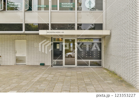 The entrance to a contemporary fitness center featuring large glass windows and a minimalist design, emphasizing wellness and physical training. The entrance to a contemporary fitness center featuring large glass windows and a minimalist design, emphasizing wellness and physical training. 123353227