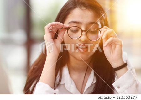 Beautiful portrait of a young woman and female student, while working on her computer or laptop at the office table. 123353277